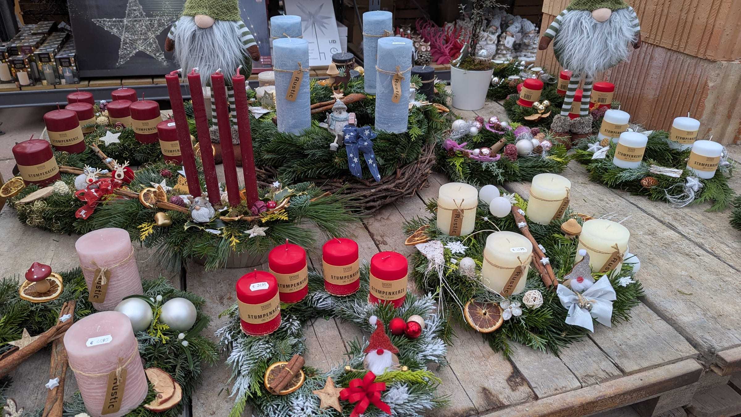 Fertige Adventsgestecke mit Kerzen auf einem Tisch