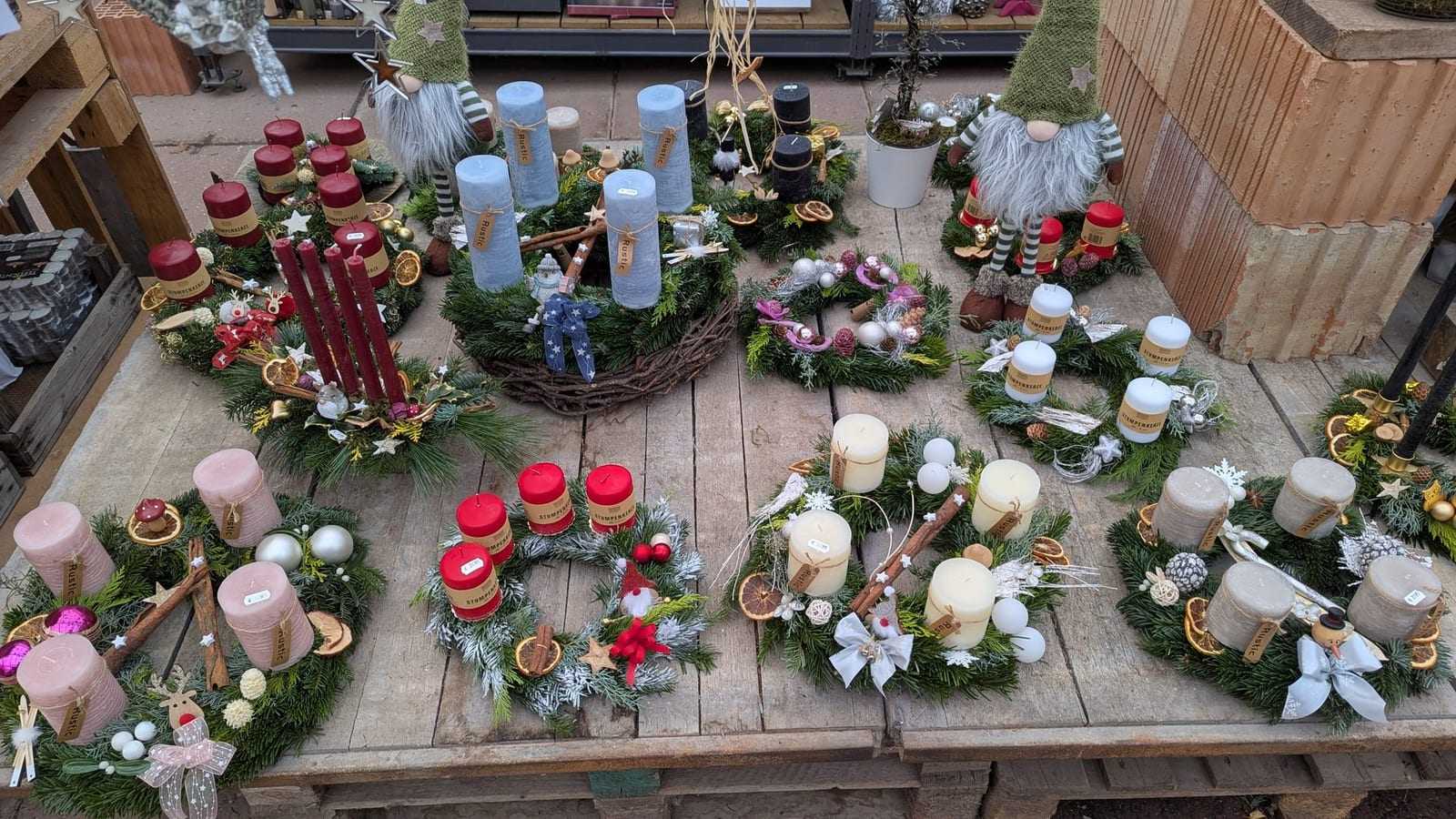 Draufsicht auf das Adventssortiment mit Gestecken, Kerzen und Zapfen